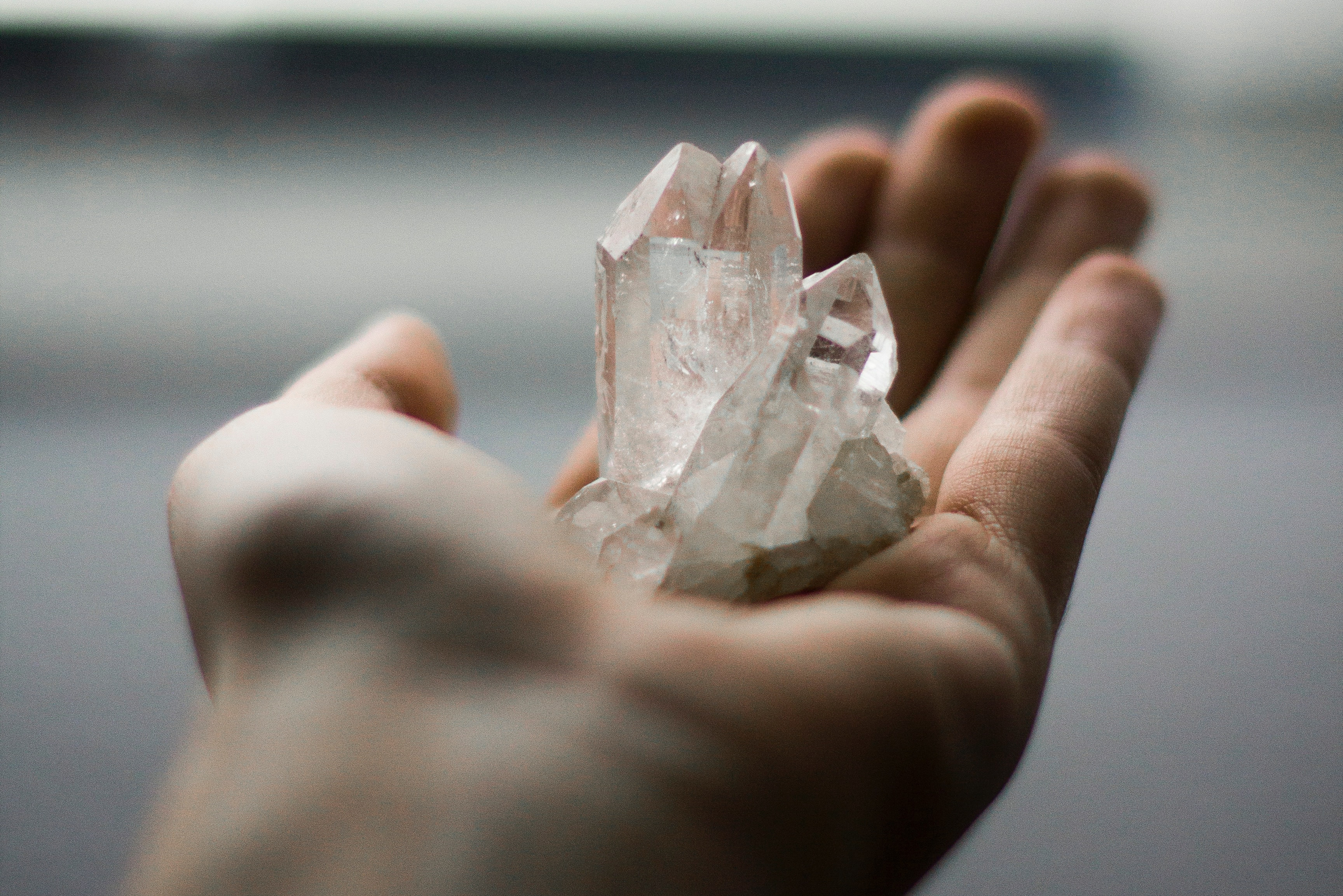 Unser Kontakt hier und jetzt - Eine Hand ist zur Schale geformt und hält einen Handtellergroßen Bergkristall
